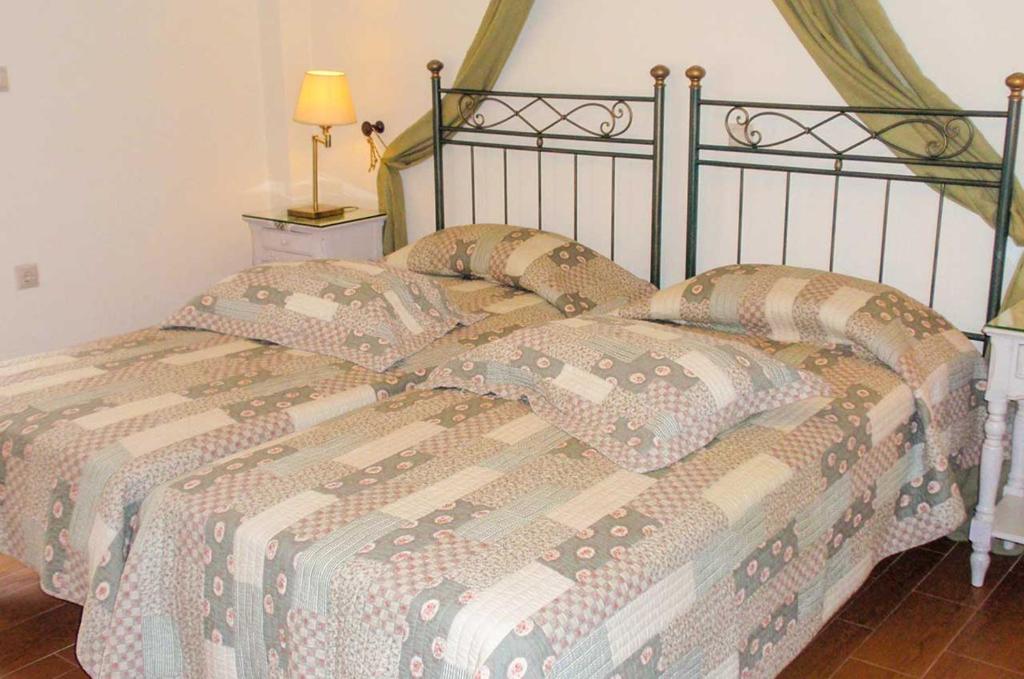 a bed with a quilt and pillows on it at Kerveli Luxury Villa in Kerveli