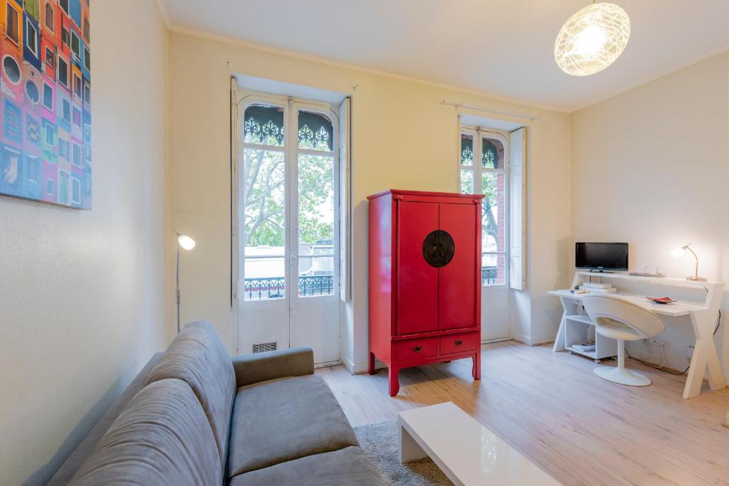 salon z kanapą i czerwoną szafką w obiekcie Le Bord de Garonne w Tuluzie