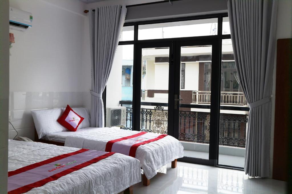 ein Hotelzimmer mit 2 Betten und einem großen Fenster in der Unterkunft Anh Quân Hotel in Quy Nhon