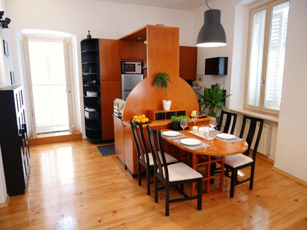 uma cozinha e sala de jantar com mesa e cadeiras em 3PAPIGE Apartment em Piran