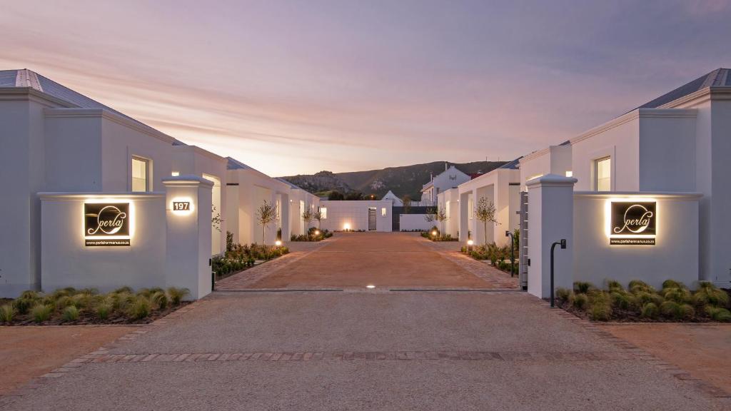 uma longa rua de casas brancas à noite em Perla em Hermanus