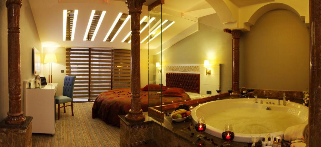 a large bathroom with a tub and a bed at Revag Palace Hotel in Sivas