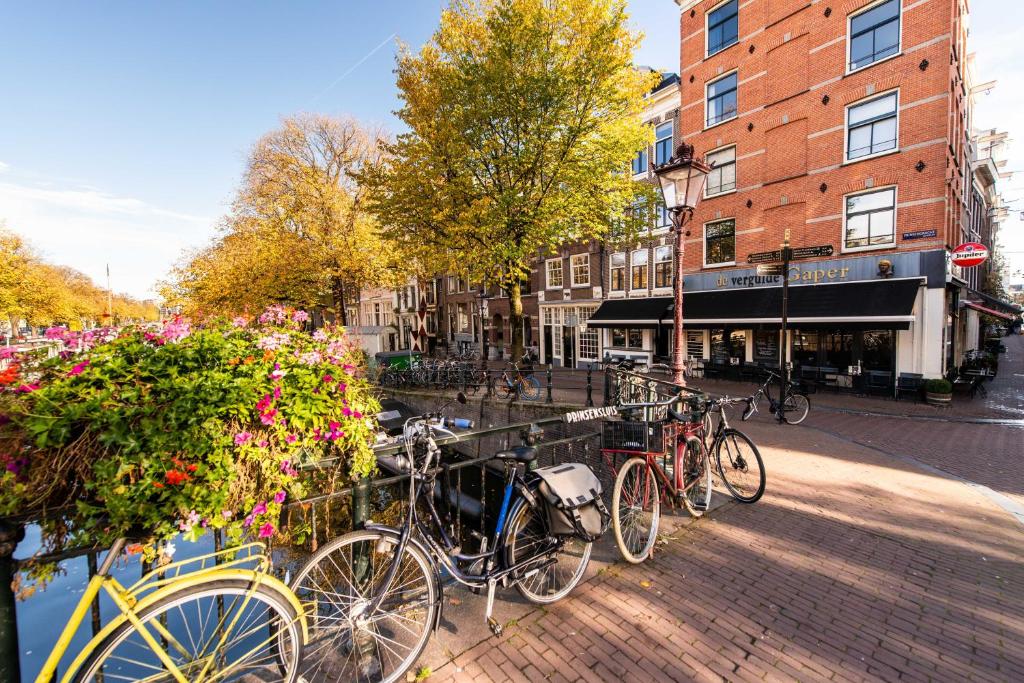 a group of bikes parked on a brick sidewalk at Prinsengracht Canal Studios in Amsterdam