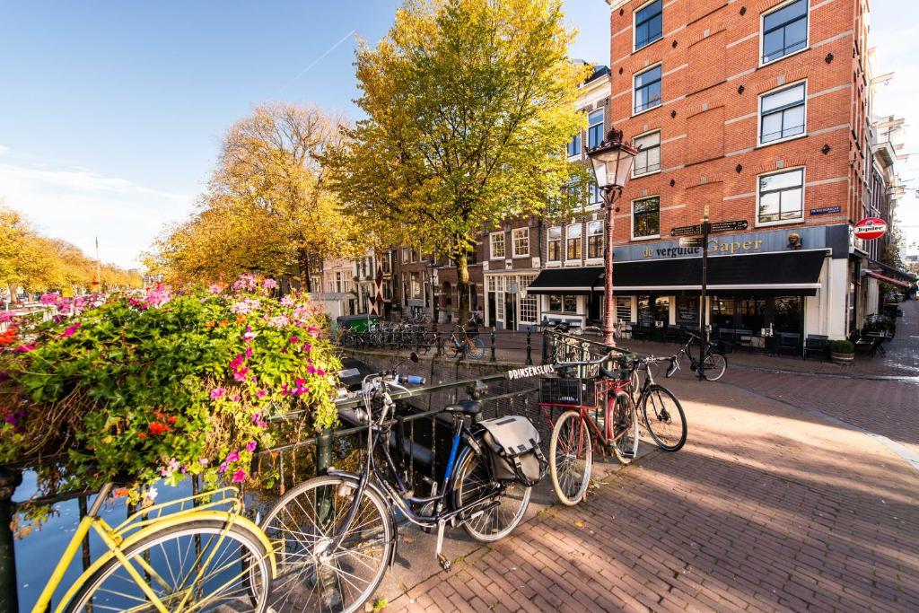 um grupo de bicicletas estacionadas numa calçada de tijolos em Prinsengracht Canal Studios em Amesterdão