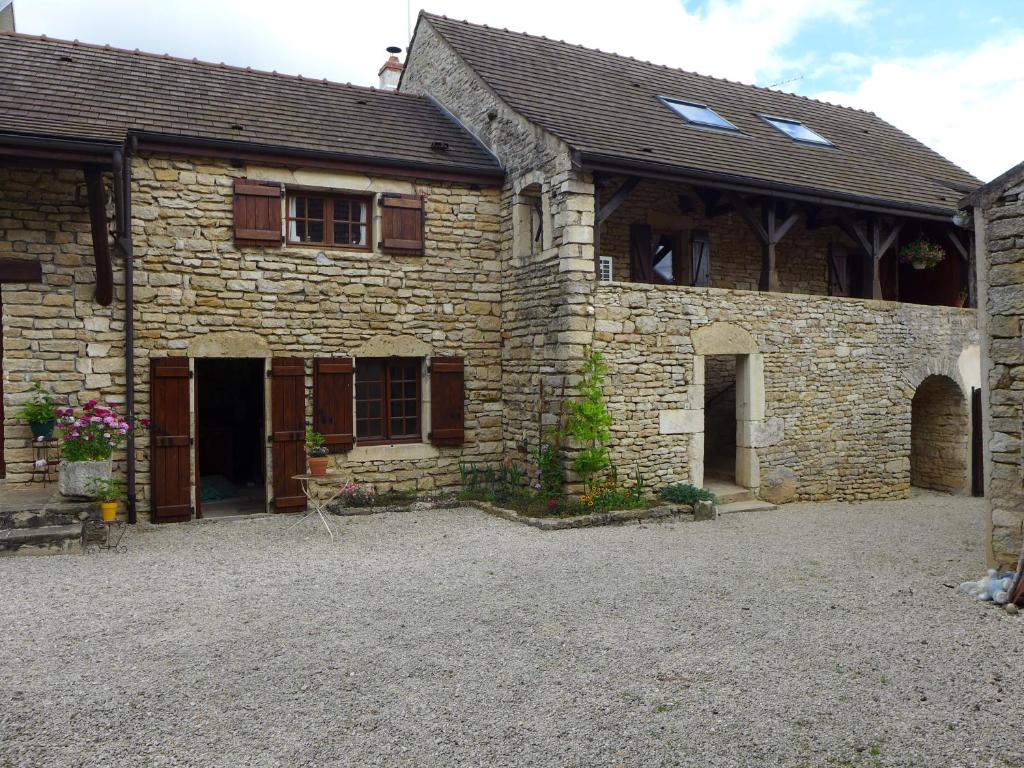 an old stone house with a large driveway in front of it at La Luterne in Villaines-les-Prévôtes