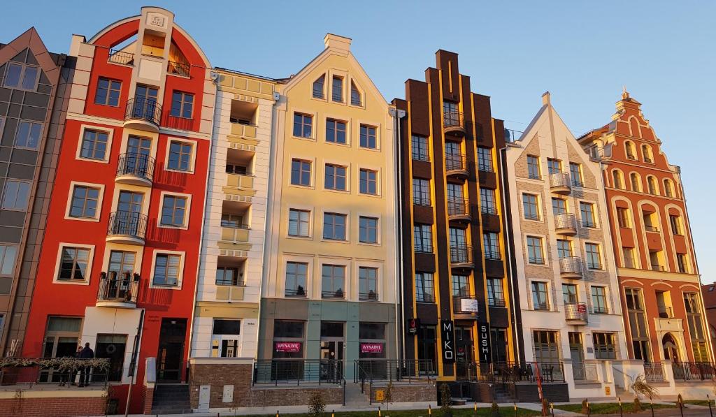 a row of colorful buildings next to each other at Apartamenty Elbląg in Elblag