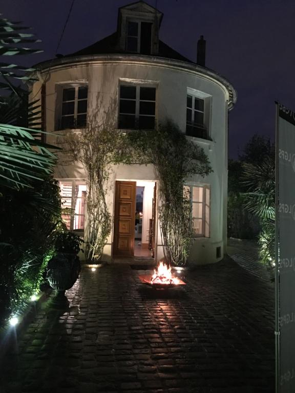 una hoguera frente a una casa por la noche en Villa Raspail en Ivry-sur-Seine