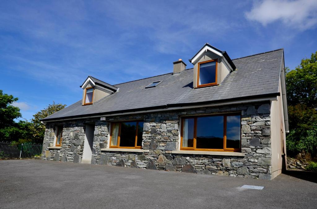 a stone house with a gray roof and windows at Cottage 173 - Clifden in Clifden