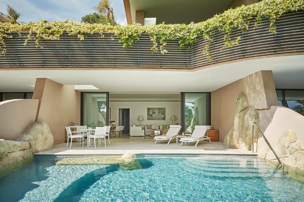 a house with a swimming pool in front of a house at Grand-Hôtel du Cap-Ferrat, A Four Seasons Hotel in Saint-Jean-Cap-Ferrat