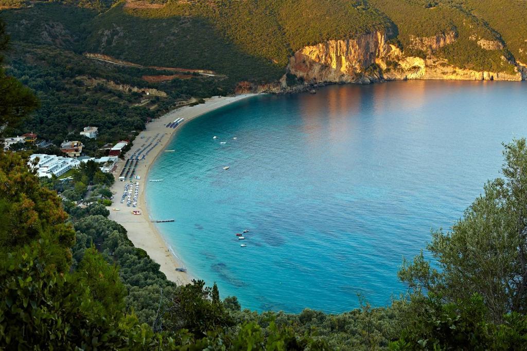 a beach with a group of people on the shore at Lichnos Beach in Parga