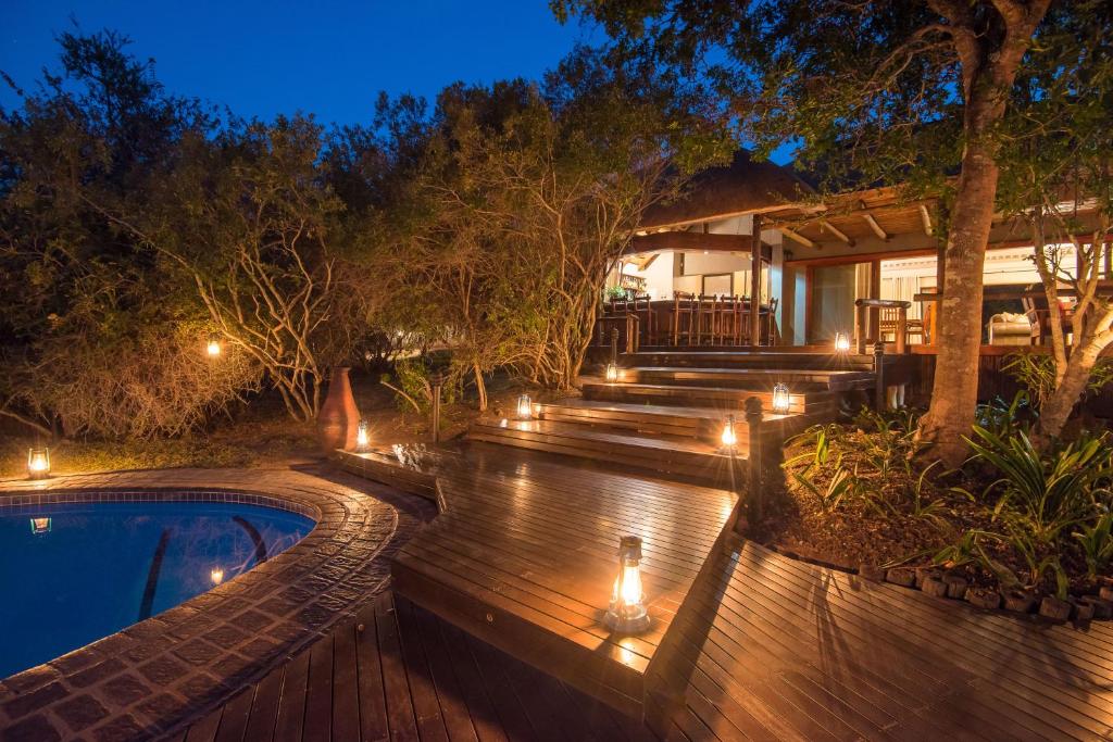 a backyard with a pool with lights and a house at Waterbuck Game Lodge Thornybush Nature Reserve in Thornybush Game Reserve