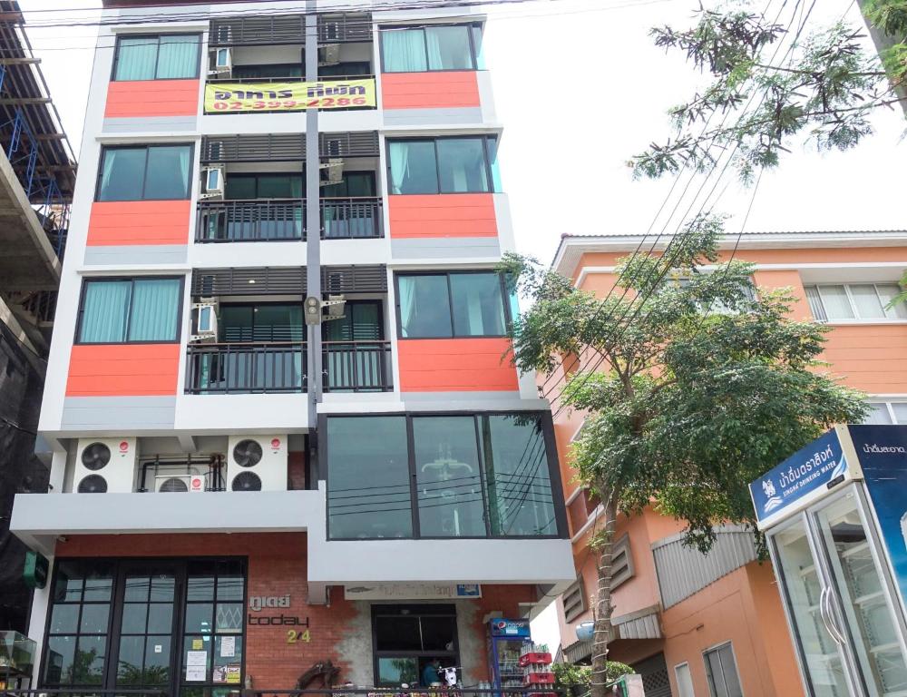 un immeuble d'appartements avec des tons orange et blanc dans l'établissement Today Tonight, à Bangkok