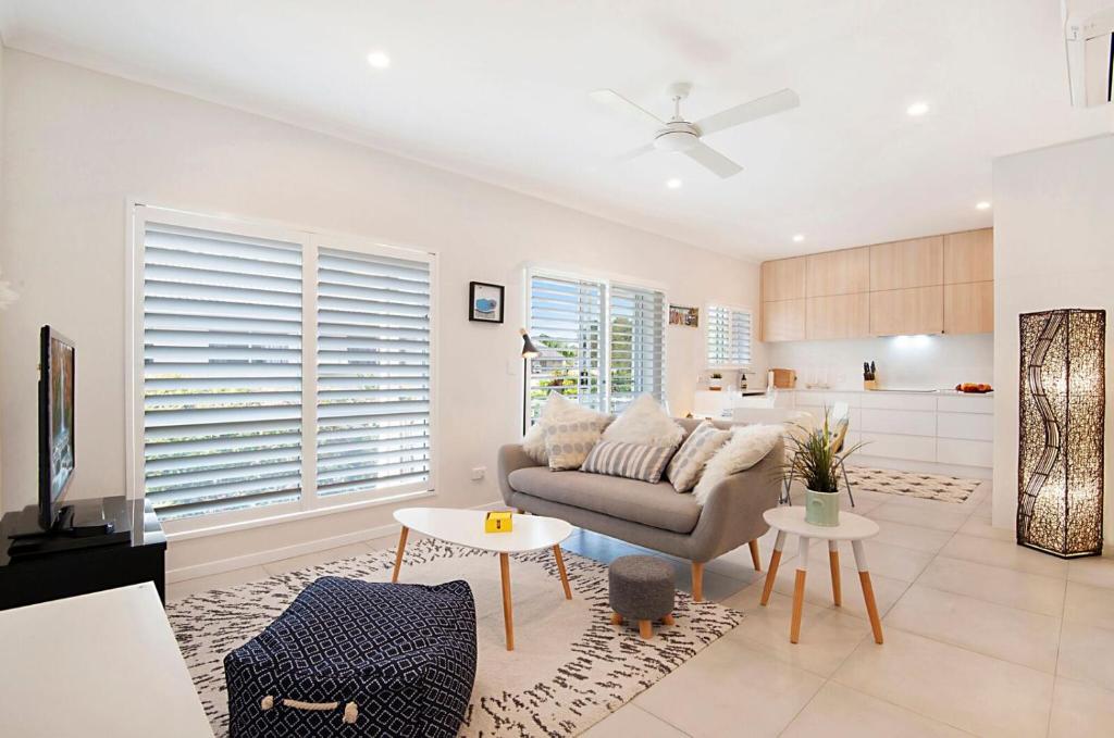 a living room with a couch and a kitchen at Durramboi Luxury Apartment in Noosaville