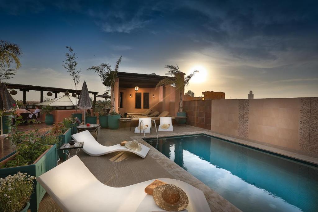 a backyard with a swimming pool and a house at Riad & Spa Bahia Salam in Marrakech