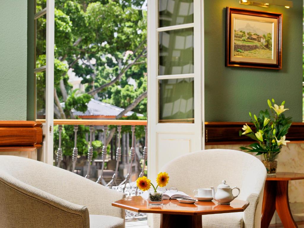 a dining room with a table and chairs and a window at Hotel Principe Paz in Santa Cruz de Tenerife