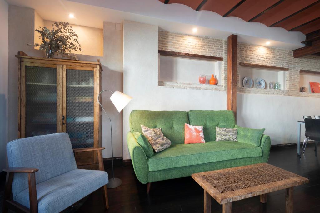 グラナダにあるPatio del Olivoのリビングルーム(緑のソファ、椅子付)
