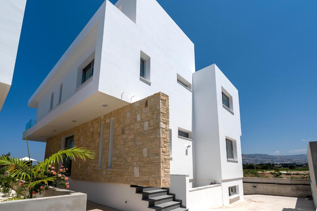 a white house with a stone wall at Sea Point Villas in Coral Bay