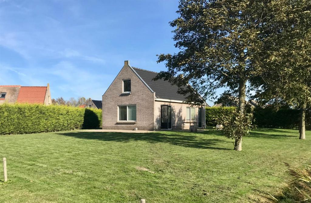 a house with a yard with a tree at Stinswoning "de Wadden" in Tzummarum in Tzummarum