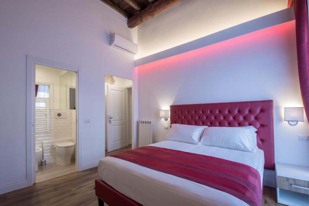 a bedroom with a large bed with a red headboard at Magenta Collection Argentina in Rome