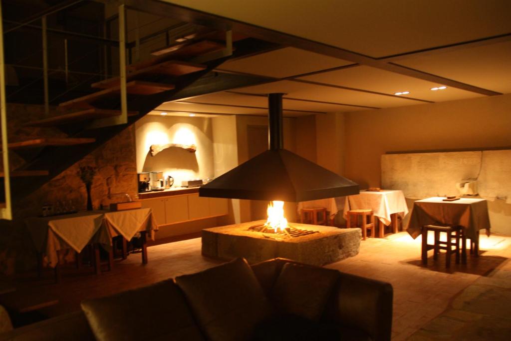 une chambre avec une table et une cheminée au milieu dans l'établissement Casa de Campo Moinhos da Gozundeira, à Sobral de Monte Agraço