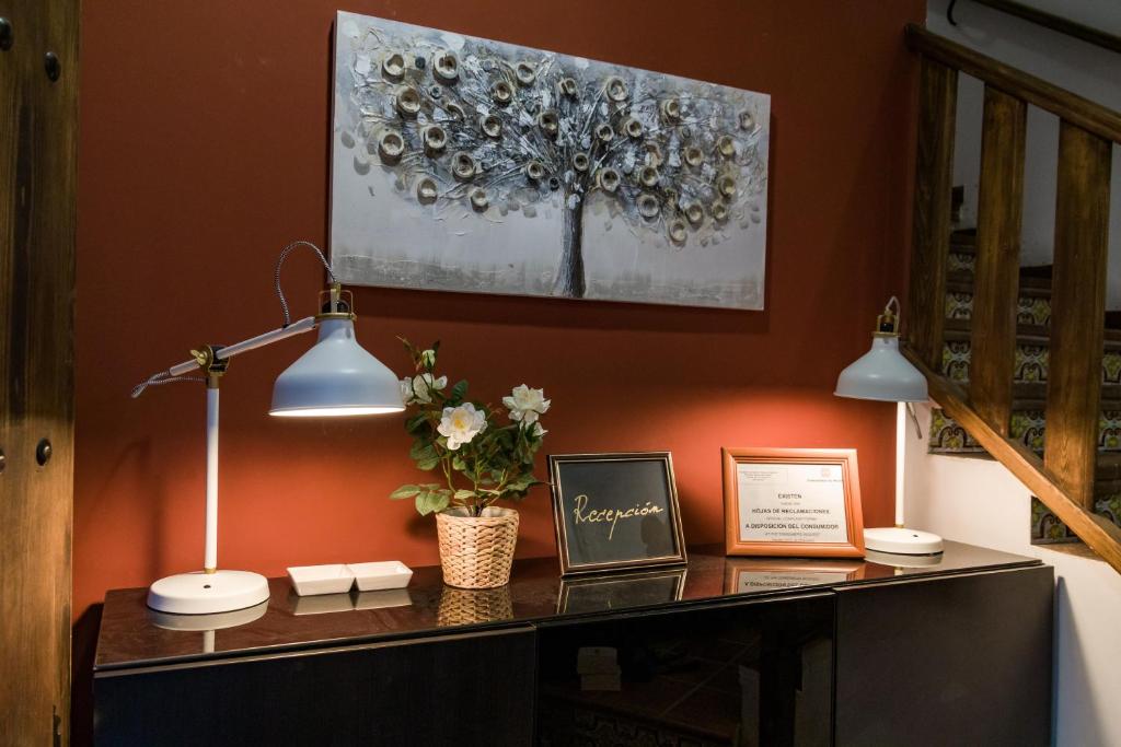 a desk with two lights and a picture on a wall at La Arbolada in Navacerrada
