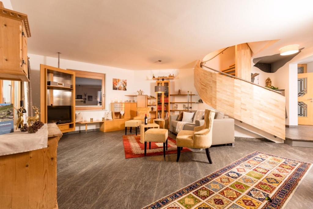 ein Wohnzimmer mit einer Treppe und ein Wohnzimmer mit einem Sofa in der Unterkunft Villa Heimatliebe in Ramsau im Zillertal