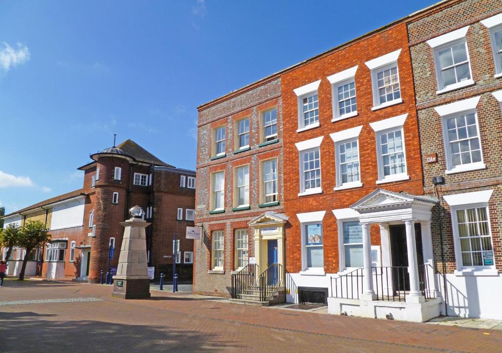 a brick building with a statue in front of it at The Georgian Apartment in Gosport