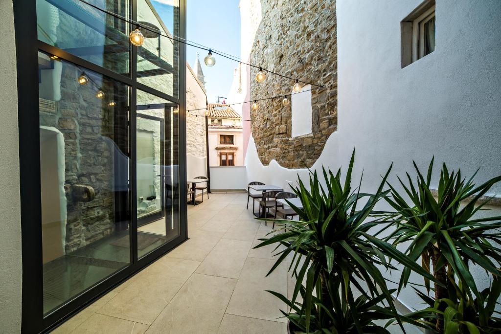 an internal courtyard of a building with potted plants at MEMENTO B&B Piran in Piran