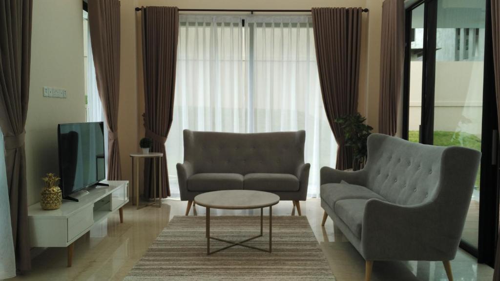 a living room with two chairs and a tv at SleepRest @ Nagoya Valley in Nagoya
