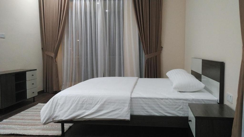 a bedroom with a white bed and a window at SleepRest @ Nagoya Valley in Nagoya