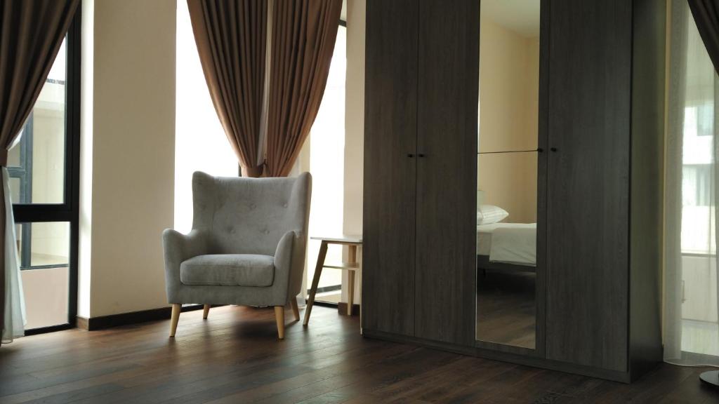 a living room with a chair and a mirror at SleepRest @ Nagoya Valley in Nagoya