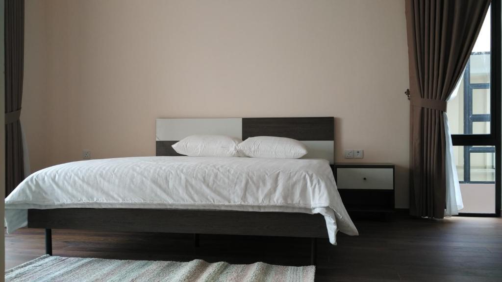 a bedroom with a bed with white sheets and pillows at SleepRest @ Nagoya Valley in Nagoya