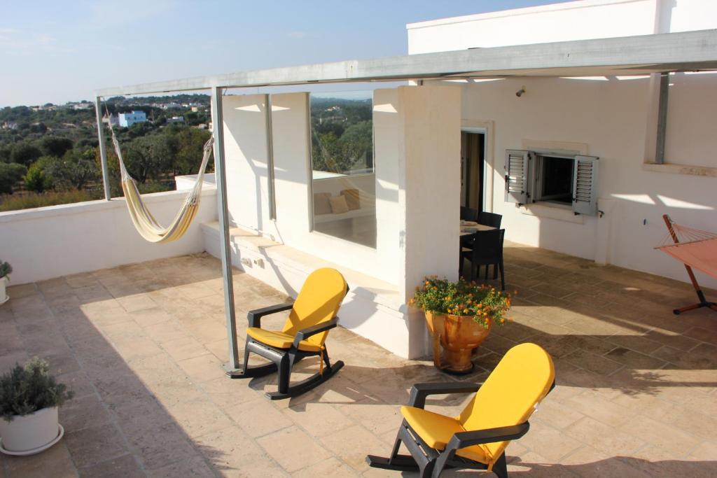 eine Terrasse mit Stühlen und einem Tisch auf dem Dach in der Unterkunft Dimora Gialla Masseria Poesia in Cisternino