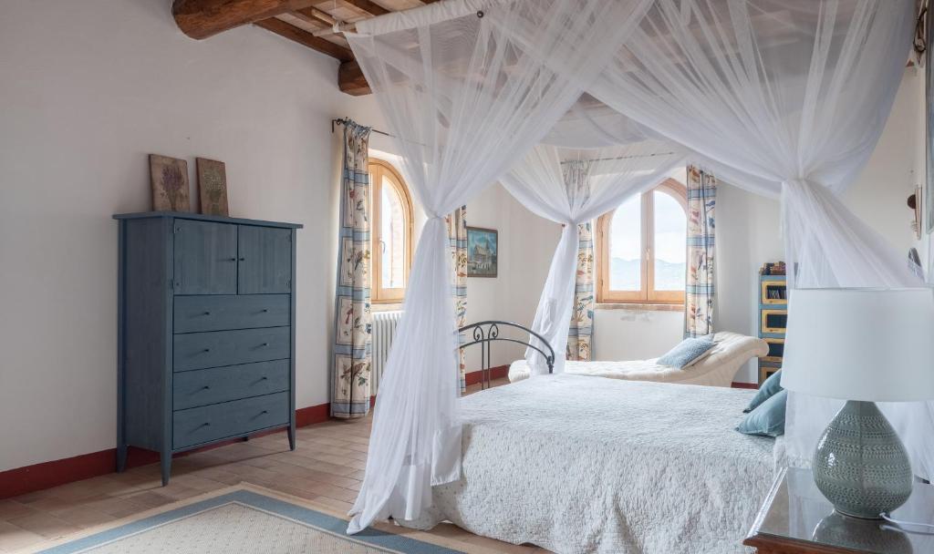 a bedroom with a canopy bed with white curtains at Farmhouse in Umbria in San Giovanni del Pantano