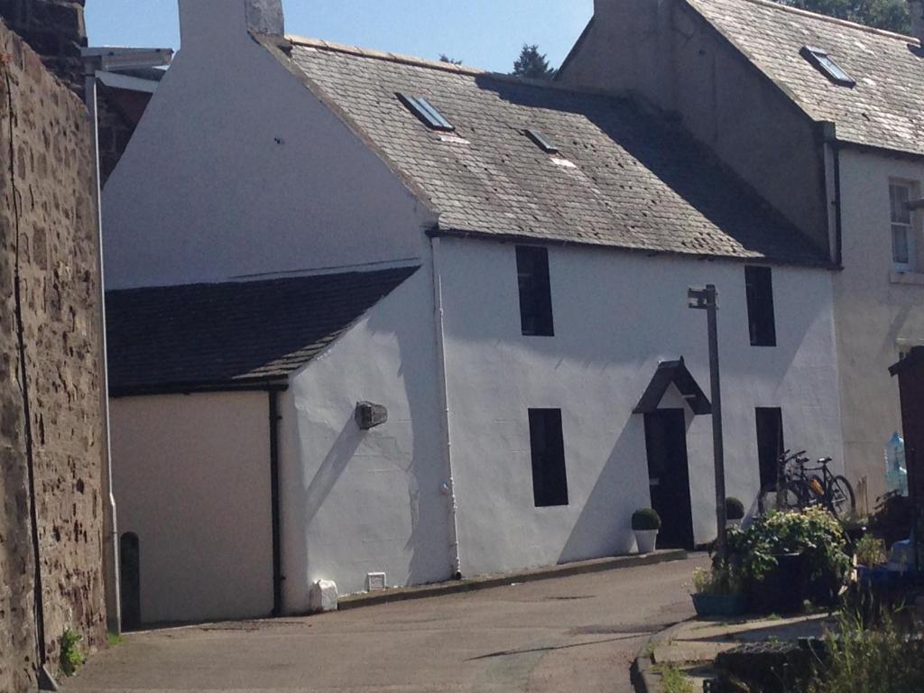 a white building with a black roof at Dunnottar Cottage in Stonehaven