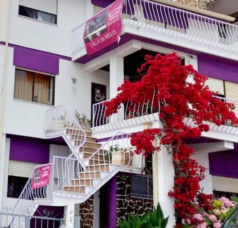 un edificio blanco con un ramo de flores rojas en Villa da Melis, en Buarcos