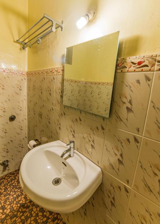 um banheiro com uma pia e um espelho em Hotel Orfil em Calangute
