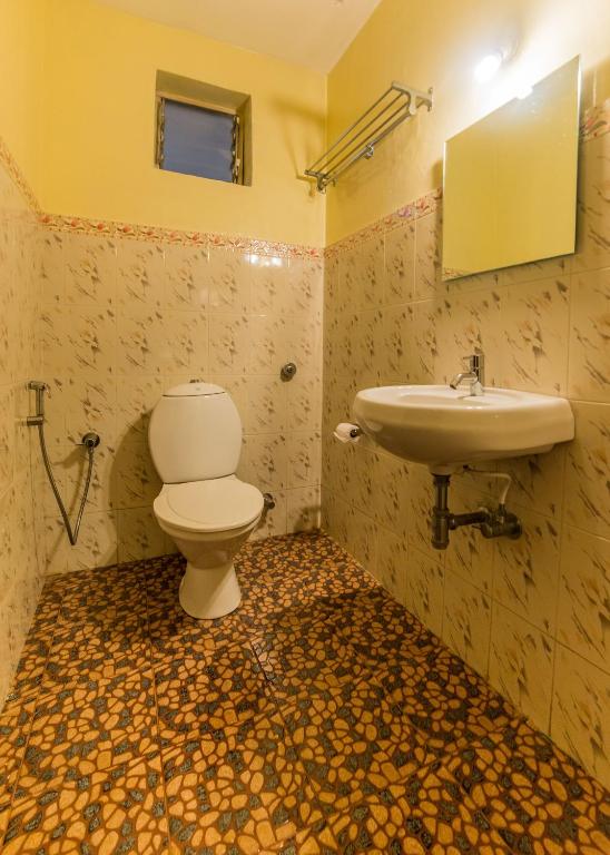 um banheiro com vaso sanitário e pia em Hotel Orfil em Calangute