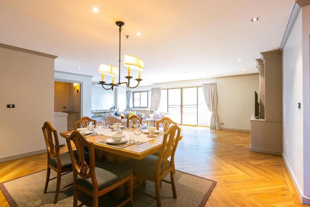 comedor con mesa y sillas en THEA Serviced Apartment by TH District, SHA Extra Plus, en Bangkok