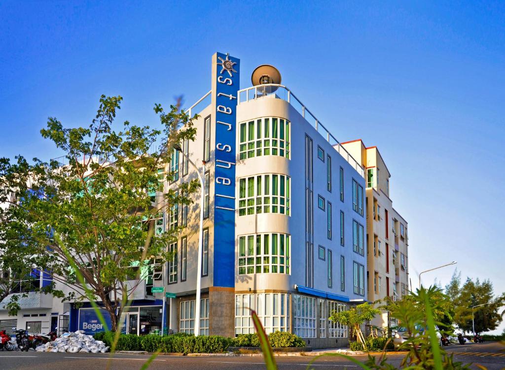 a building with a blue sign on the side of it at Hotel Star Shell in Hulhumale