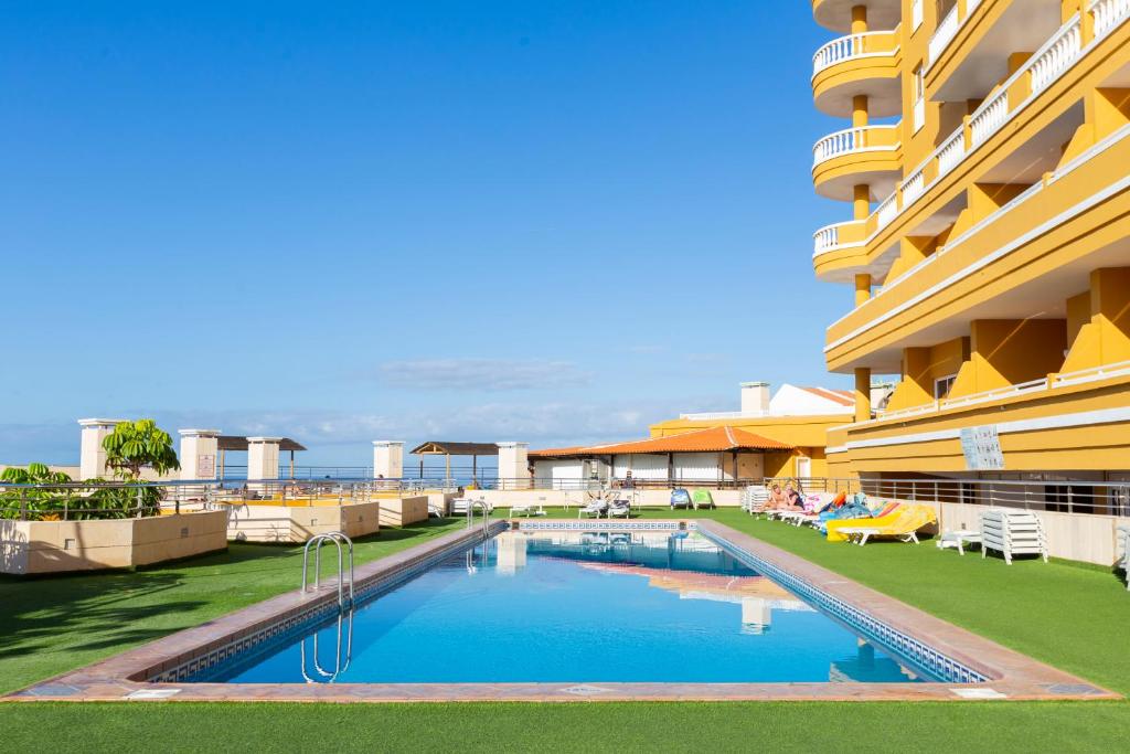 a swimming pool in front of a building at Villa De Adeje Beach in Adeje