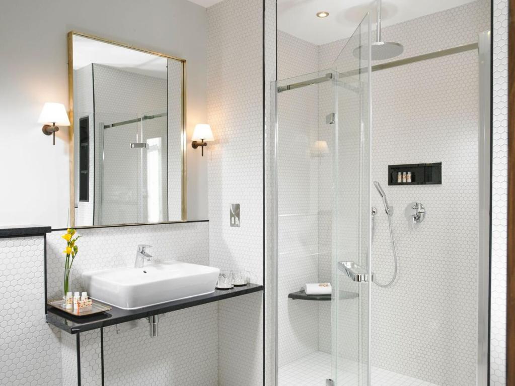 bagno con lavandino e doccia in vetro di Newpark Hotel a Kilkenny