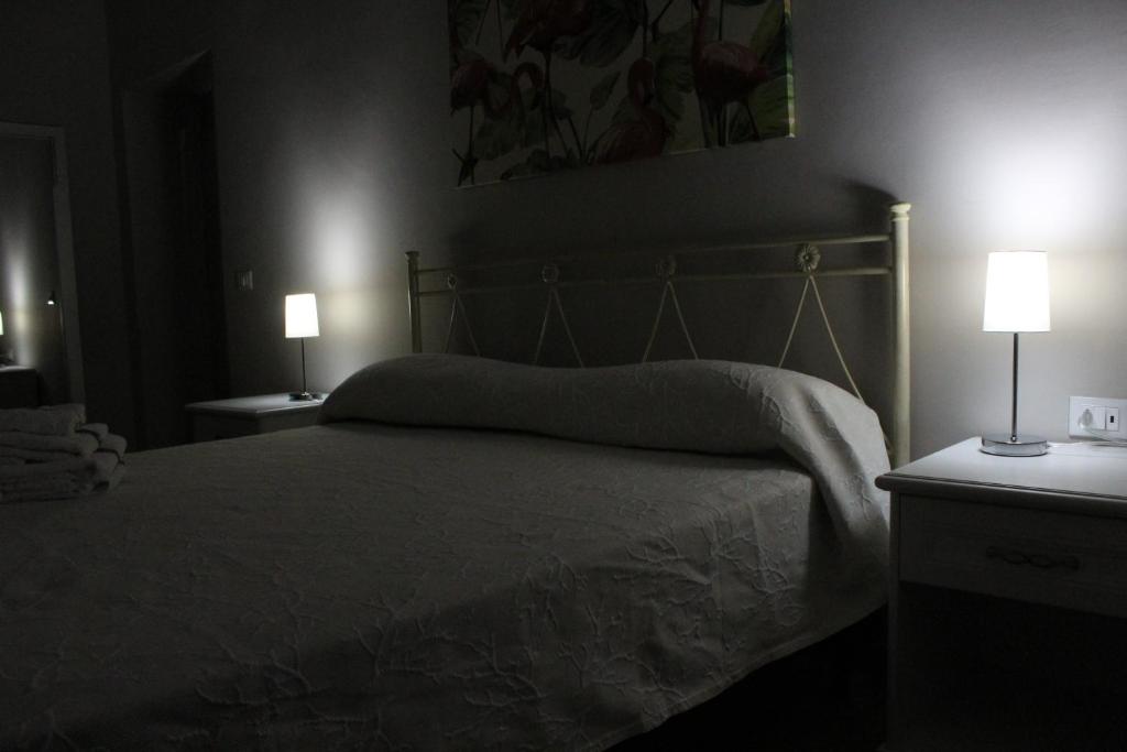 a bedroom with a bed with two lamps on it at Bed & Breakfast San Marco in Taranto