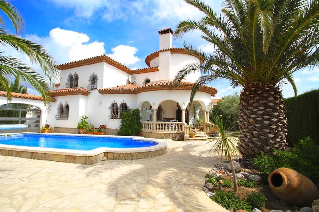 ミアミ・プラトーヤにあるMiami Playa Villas Granadaのヤシの木とスイミングプールのある家