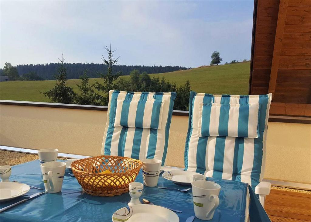 een tafel met borden en stoelen op een balkon bij Ferienwohnung am Bach in Unterkirnach