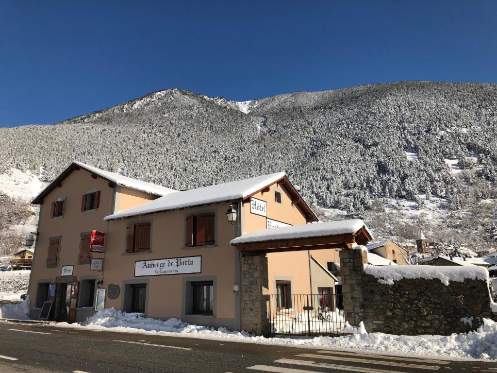 a building on the side of a snow covered mountain at Le Campcardos in Porta