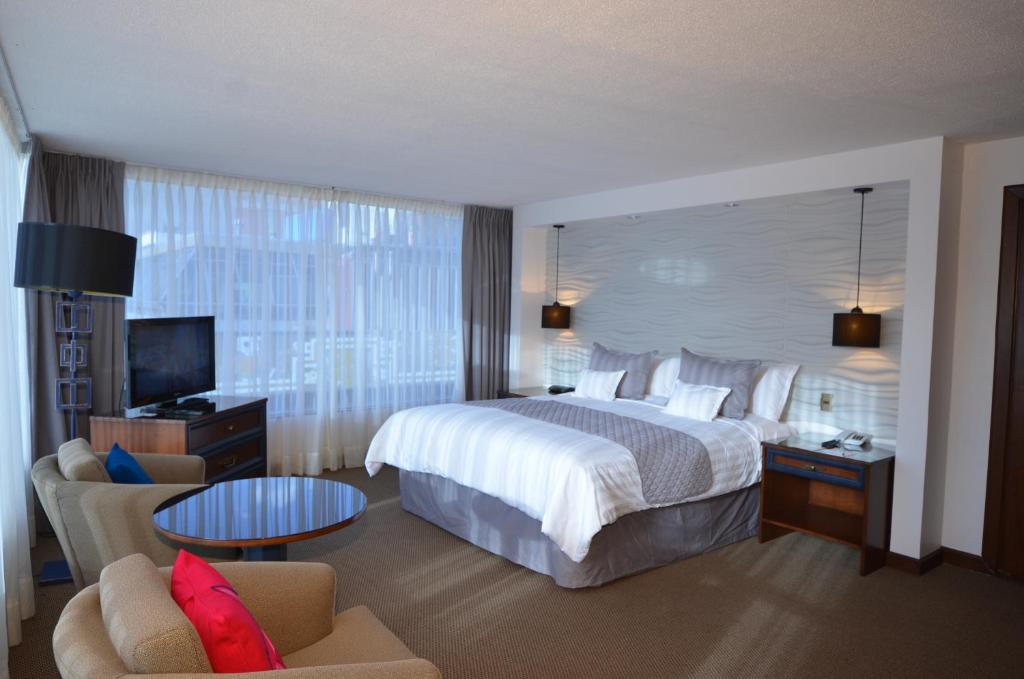 a hotel room with a large bed and a couch at Hotel Presidente in La Paz