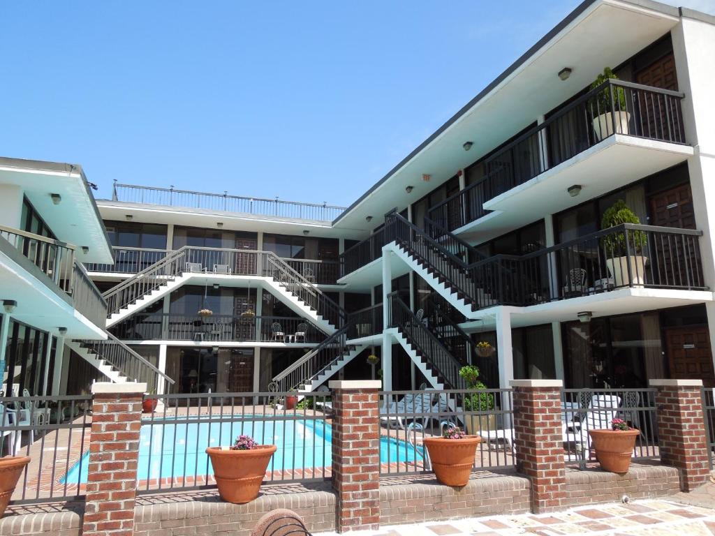 an apartment building with stairs and a swimming pool at Alamar Resort Inn in Virginia Beach