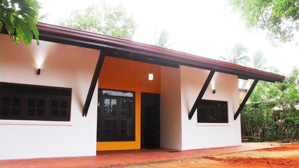 a white building with a red and yellow door at Grand Villa in Anuradhapura