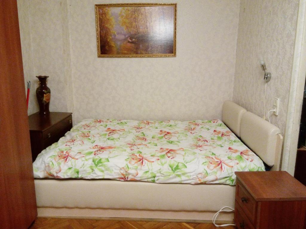 モスクワにあるУютные апартаменты на Ельнинскойの小さなベッドルーム(花柄のベッドカバー付)